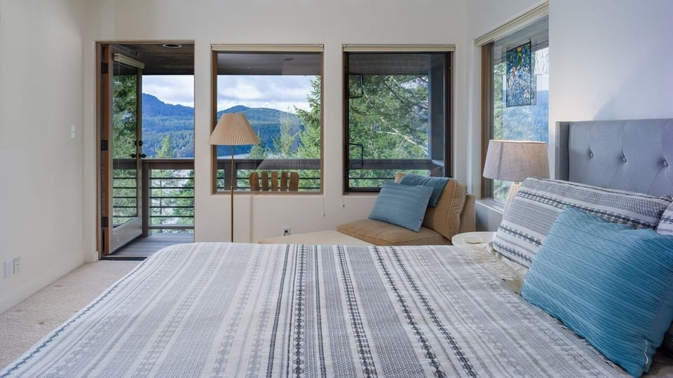 Master Bedroom with a king bed and reading area that open to a private balcony with water views.