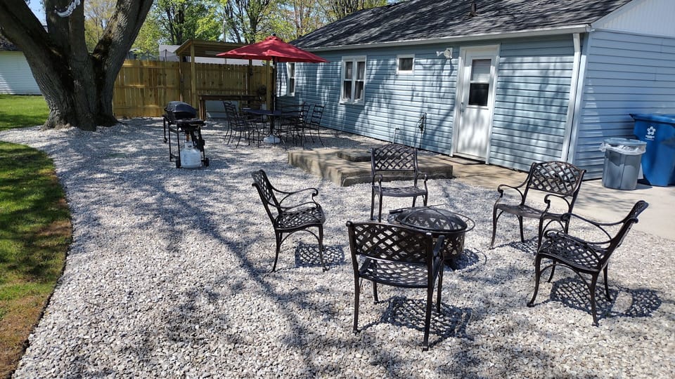 large outdoor area with gas grill, fire pit and picnic table 