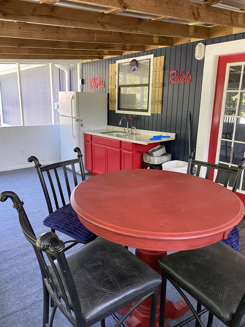Screened in back porch with seating area and sink