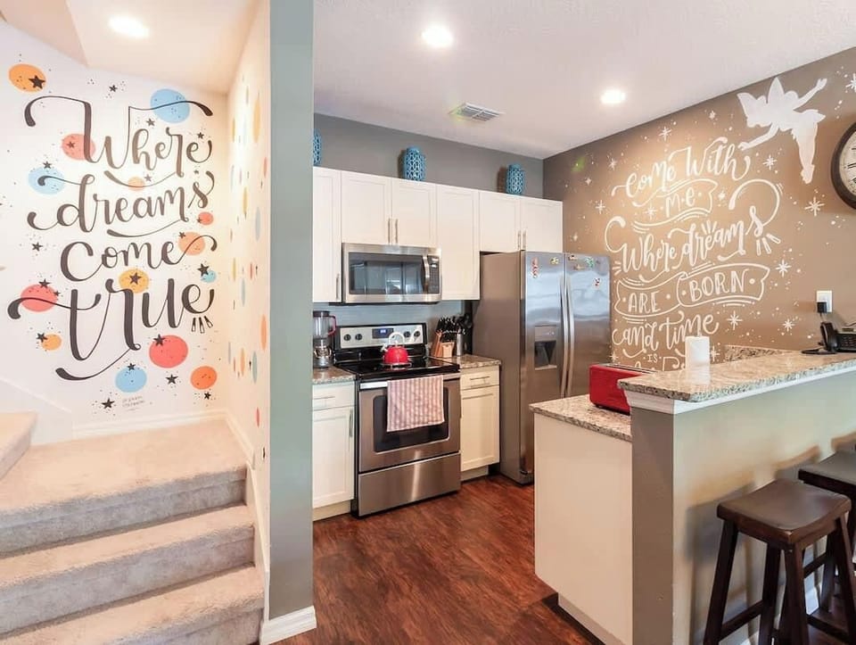 Fully equipped kitchen with charming Disney-themed wall art.