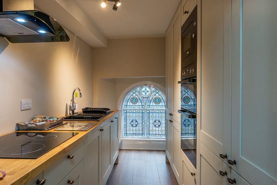 Kitchen with induction hob, two ovens and microwave.