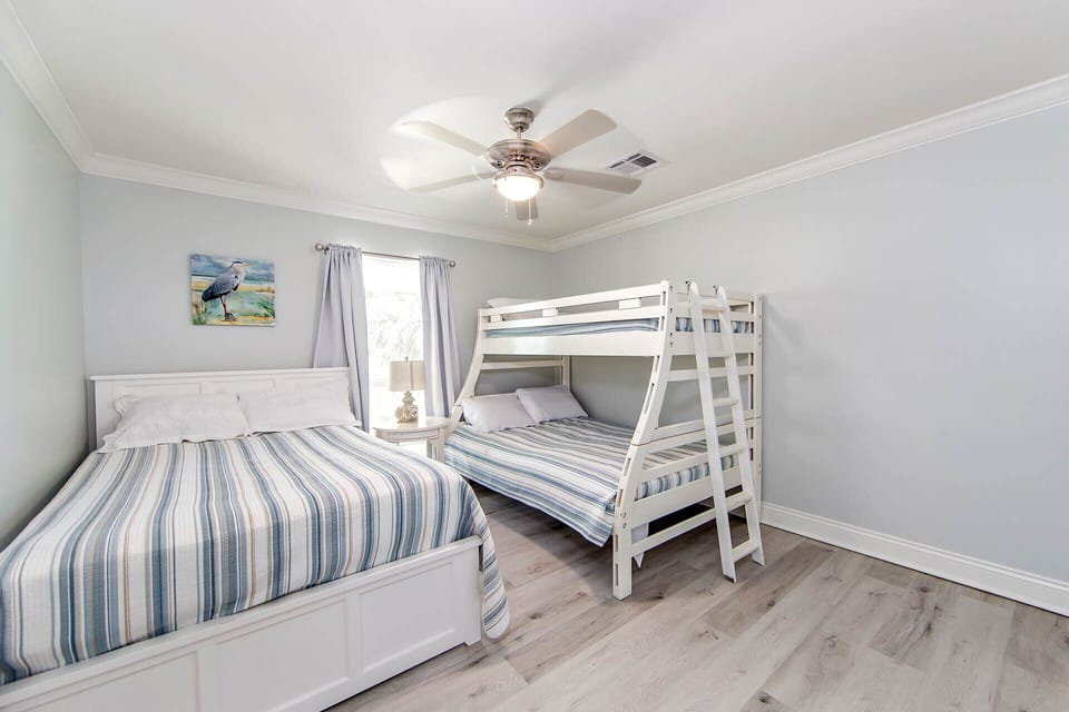 This room has a queen size bed. A set of bunks that has a twin top and a full size on the bottom. All linens provided.