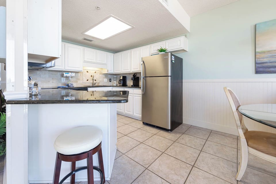 Prepare meals in the spacious kitchen, featuring sleek appliances and a breakfast bar for casual dining