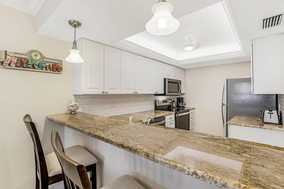 The well appointed kitchen features new appliances, granite counters and a tile backsplash.