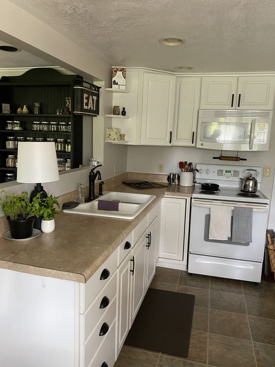 Fully stocked kitchen with microwave and stove/oven.