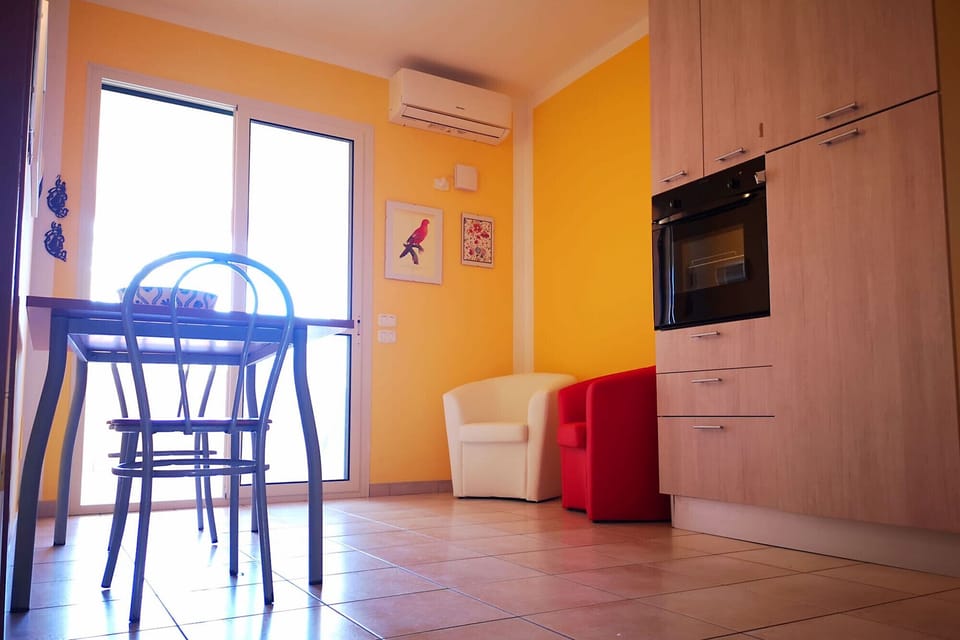 Principina mare - Bruno holiday apartment - The air-conditioned living room with the large French window that gives light to the room