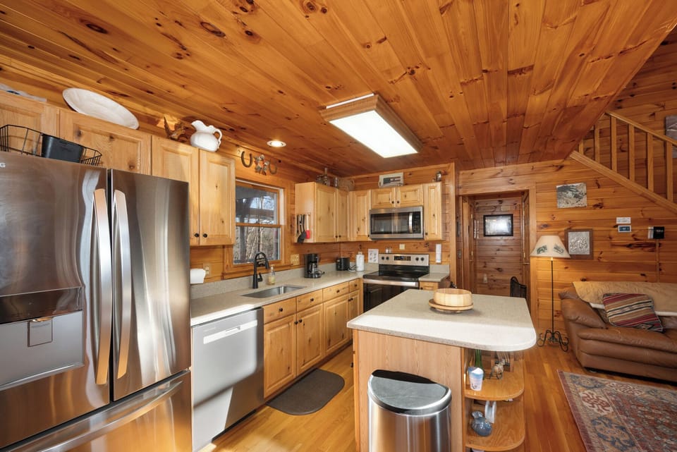 Your rustic cabin kitchen features rich wood finishes and modern appliances, creating the perfect space for cooking meals together.