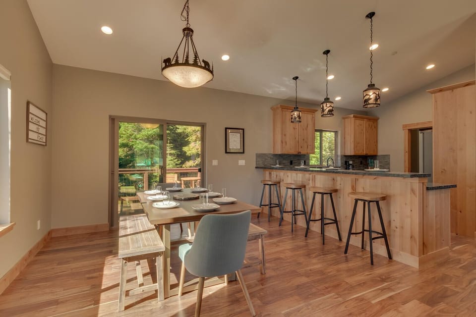 - Dining table with bench and chairs for six  
- Open layout connects to the kitchen bar  
- Easy access to outdoor deck dining