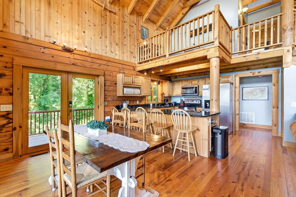 Kitchen with bar seating for 5 and dining area with deck access & seating for 4.