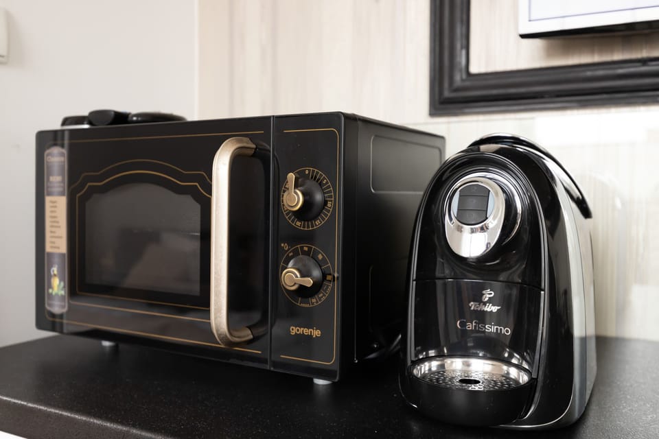 A detailed shot of the kitchen appliances, including a sleek black microwave and a coffee machine placed on the countertop.