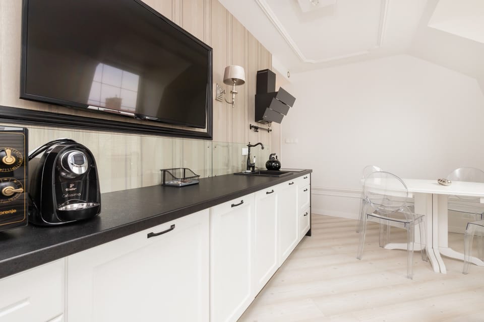Another angle of the modern kitchen, showing a black oven, microwave, and espresso machine alongside the clean white cabinetry.