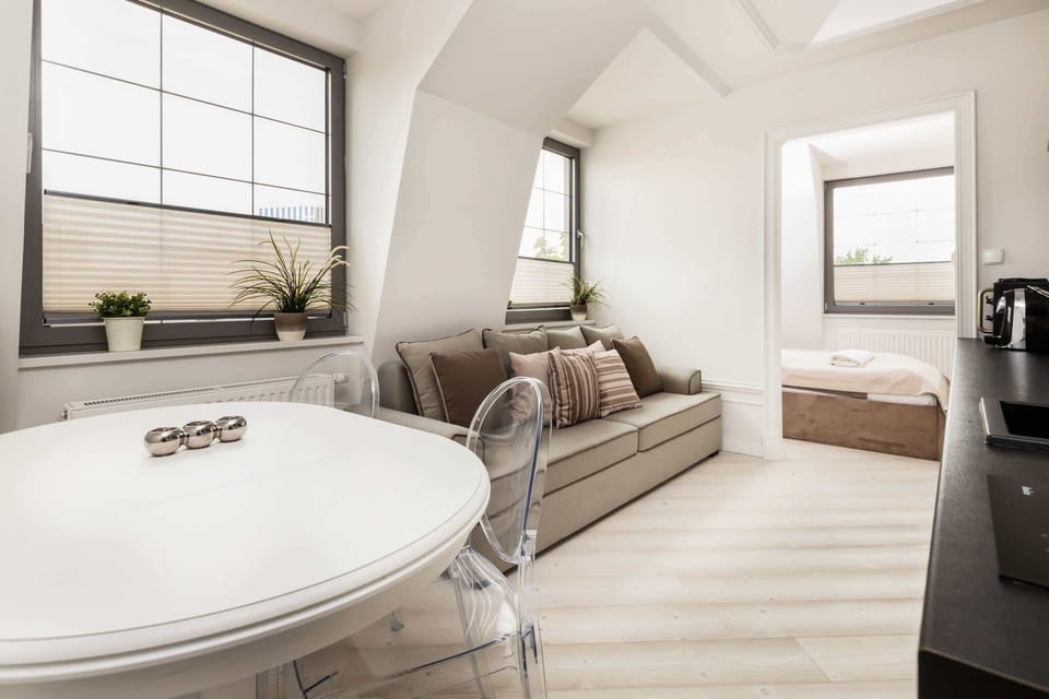 Another angle of the living room, showcasing a light gray sofa with decorative pillows and a cozy seating nook near the window.