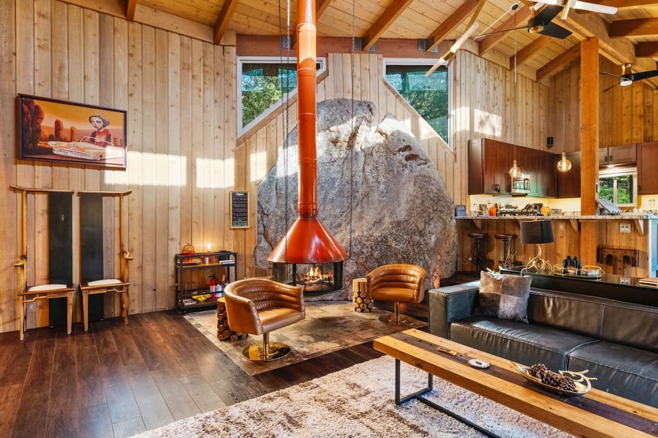 Living room featuers boulder accent, swedish style fireplace, am - Living room featuers boulder accent, swedish style fireplace, ambient lighting and comfortable seating.