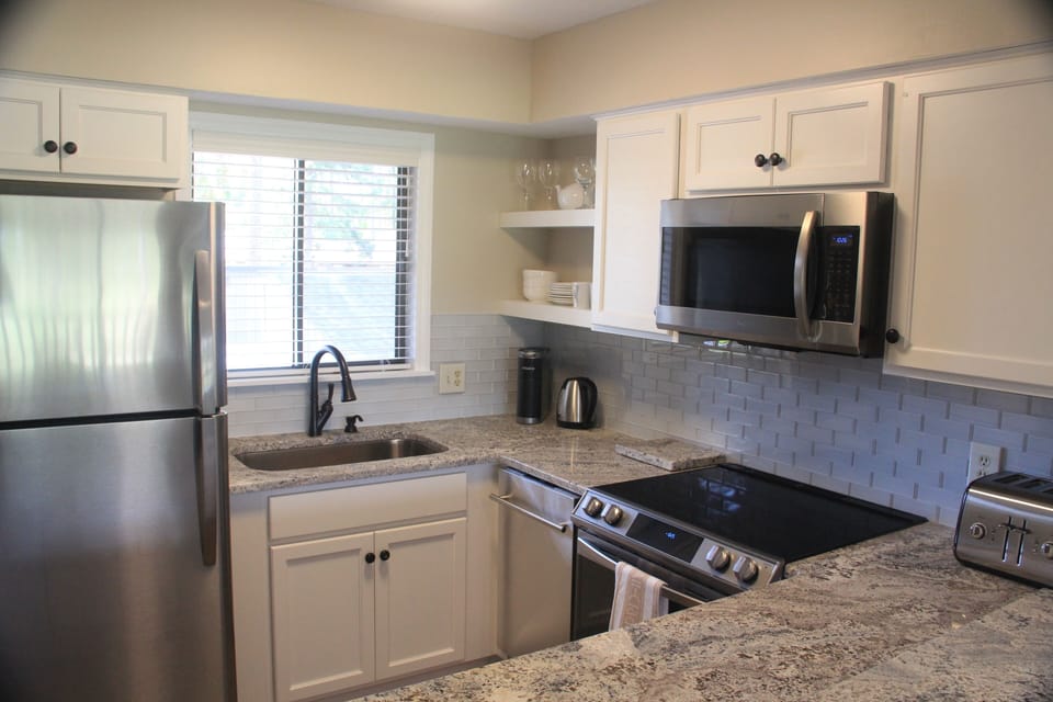 Fully-equipped kitchen with coffee maker, hot water kettle, toaster.