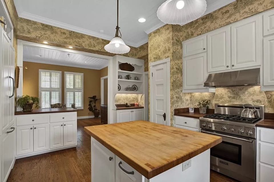 Butcher blk counter tops, high-end appliances, cookware in this large Kitchen.