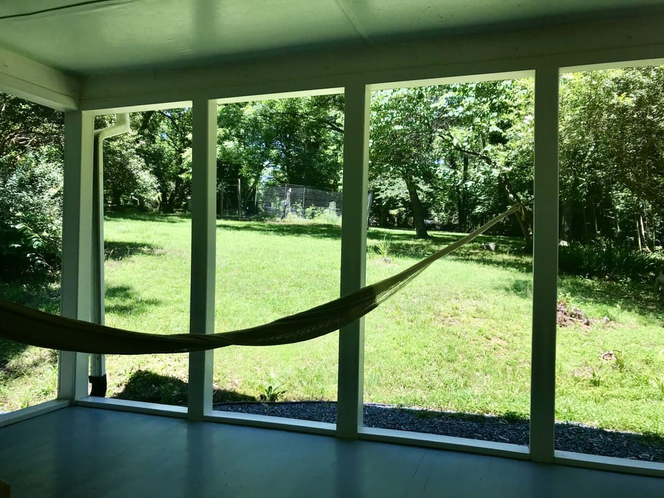 View of large, private backyard from screened in porch
