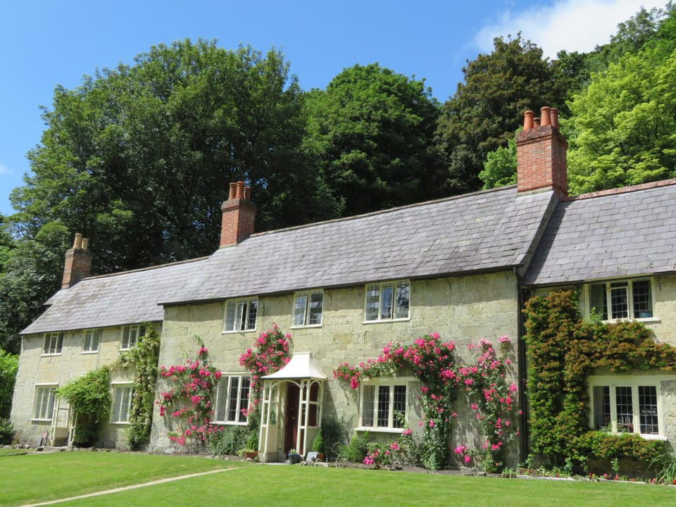 Rose clad front elevation looks towards the village church