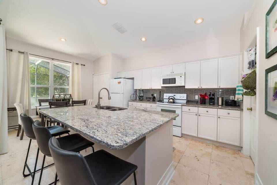 Kitchen featuring a large breakfast bar with 4 comfortable bar stools.