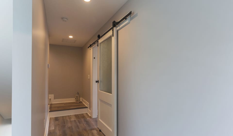 2nd Floor hall leading to Primary Suite Repurposed 110 year old local wood door!