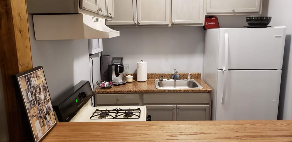 Microwave, kitchenware, coffee pot with coffee and tea, spices, popcorn. 