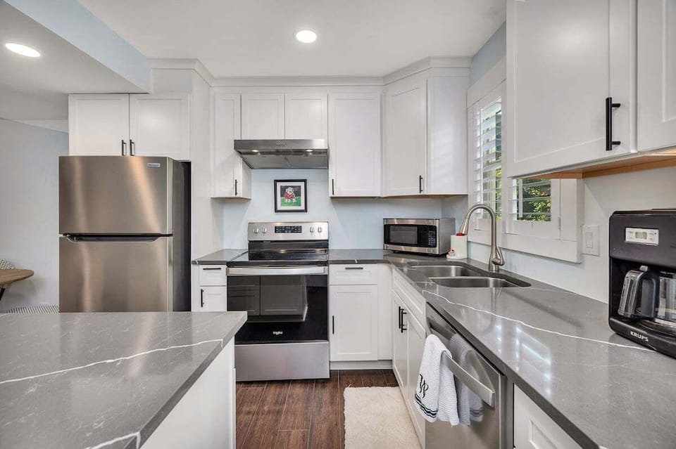 White kitchen with stainless appliances and quartz counters