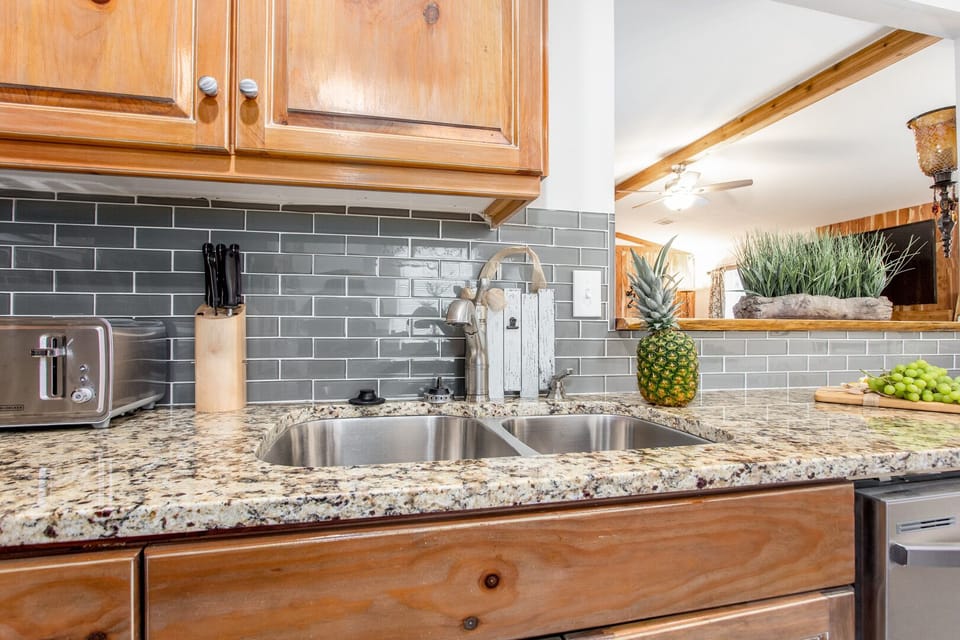 Kitchen with double sinks, knife sets, cutting boards and dish rack.