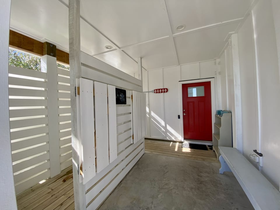 Outdoor shower is enclosed & equip with lots of hooks for towels