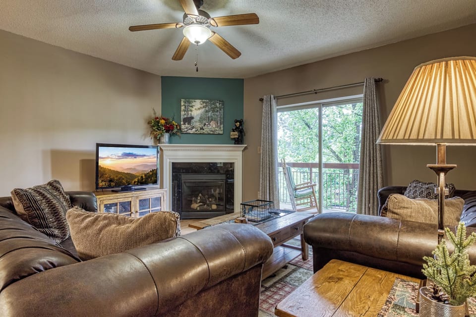 The spacious living room features a cable TV, fireplace, and balcony access.