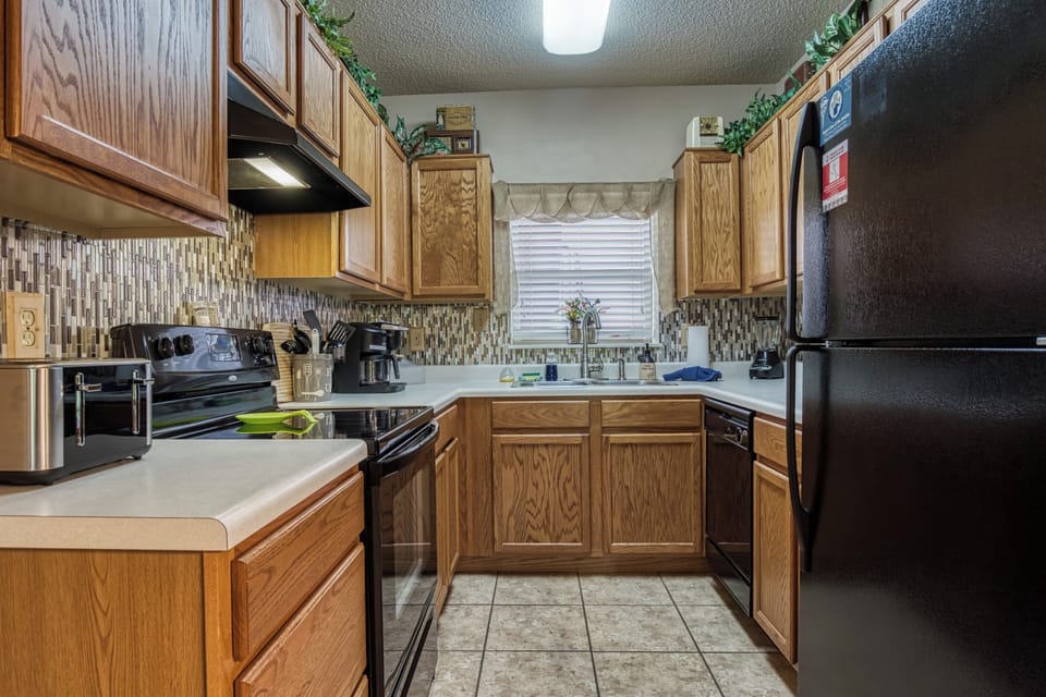 Fully stocked kitchen which features a stove, refrigerator, & dishwasher