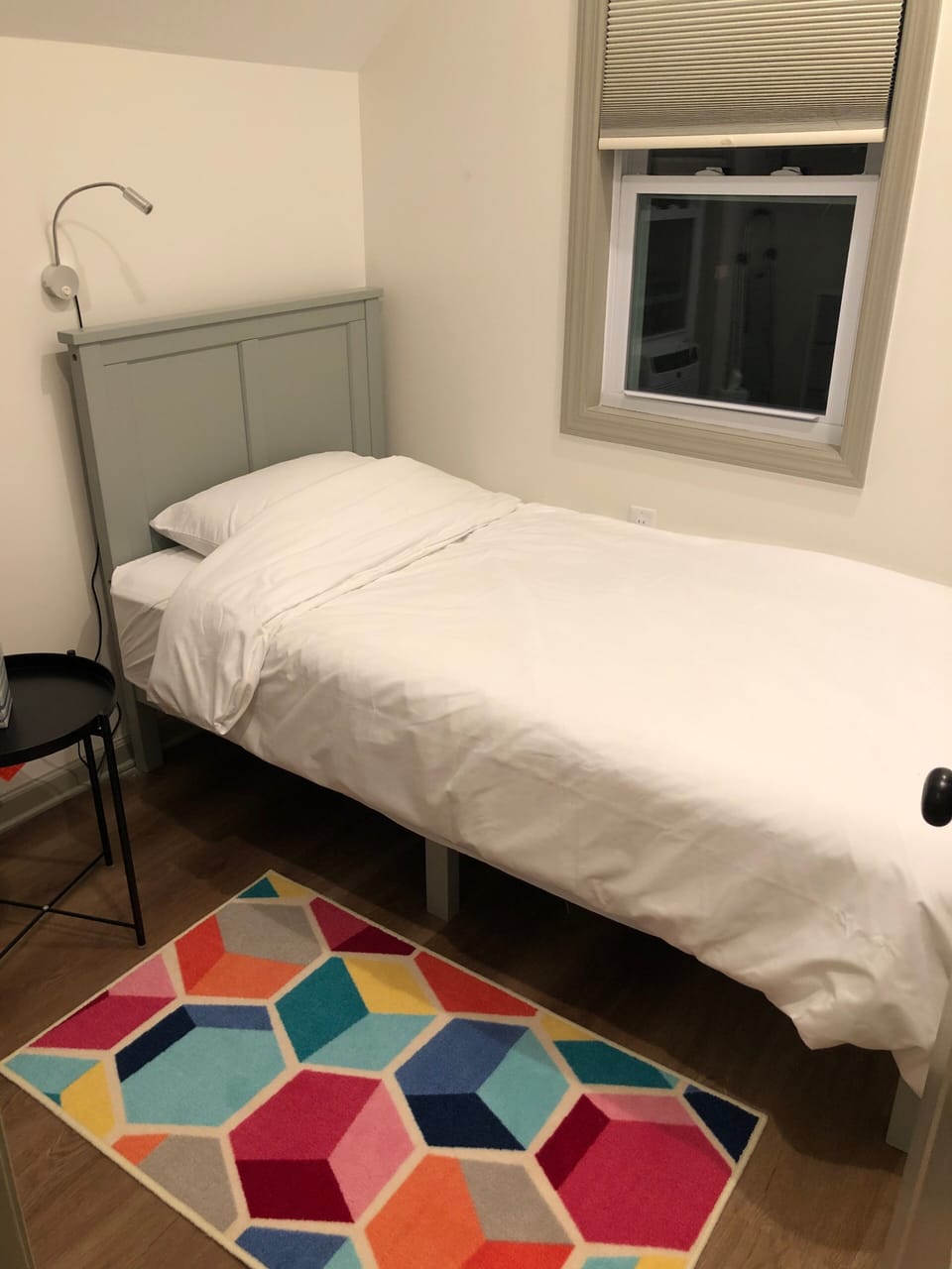 Front left bedroom with twin bed, window AC, and blackout shades