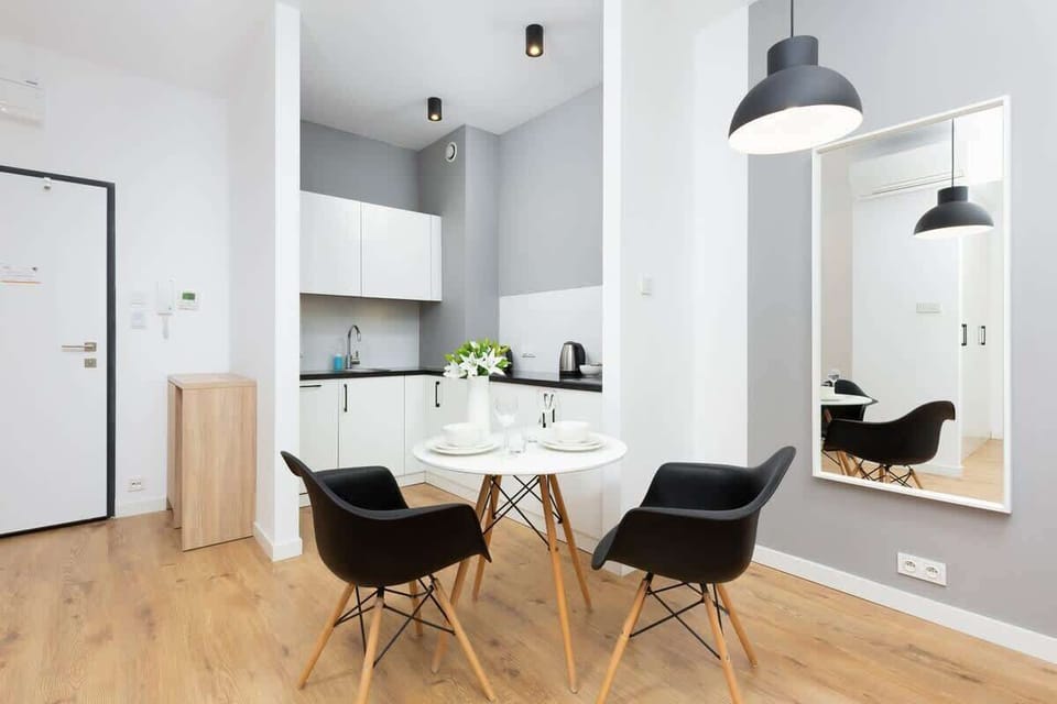 Another view of the kitchenette showing a clean, functional layout. The wooden flooring adds warmth to the minimalist style.