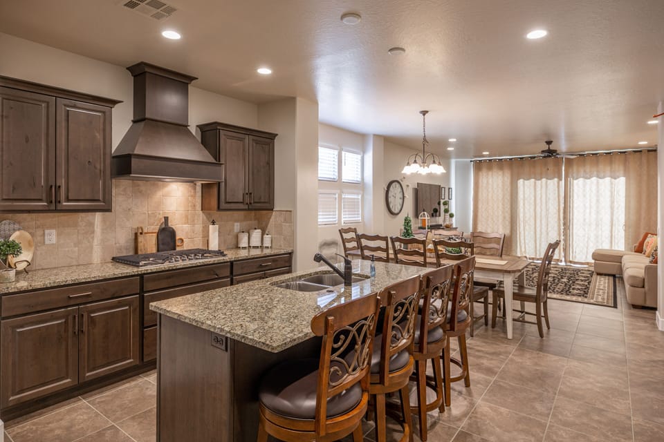 Kitchen View - The Kitchen and Dining Table can accommodate 10 adults and is stocked with pots, pans, baking sheets, mixing bowls, plates, bowls, cups, silverware, and a collection of cooking utensils.