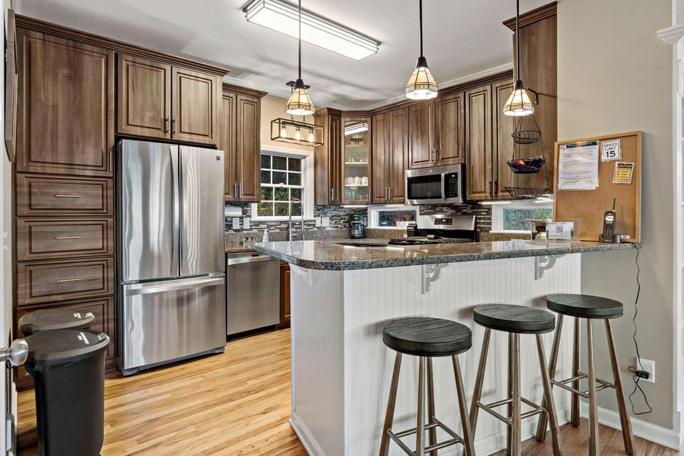 Modern kitchen with stainless appliances, gas range stove, dishwasher, Drip-style + Keurig coffeemakers & breakfast bar with seating for 3.