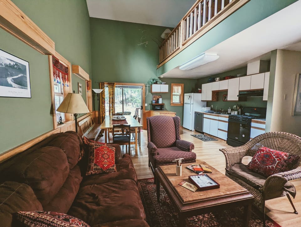 Looking into dining area and kitchen from seating area around propane fireplace