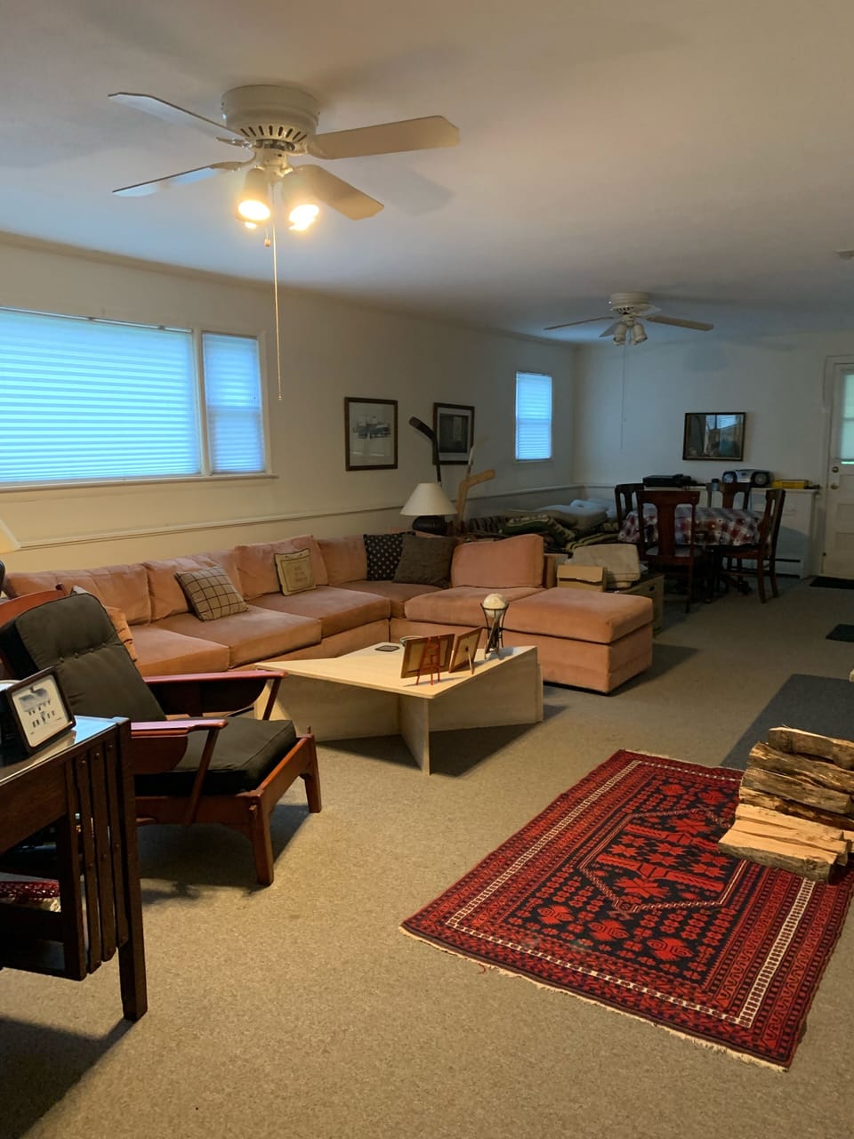 Family room with large sectional and table at end of room. Leads to screened por