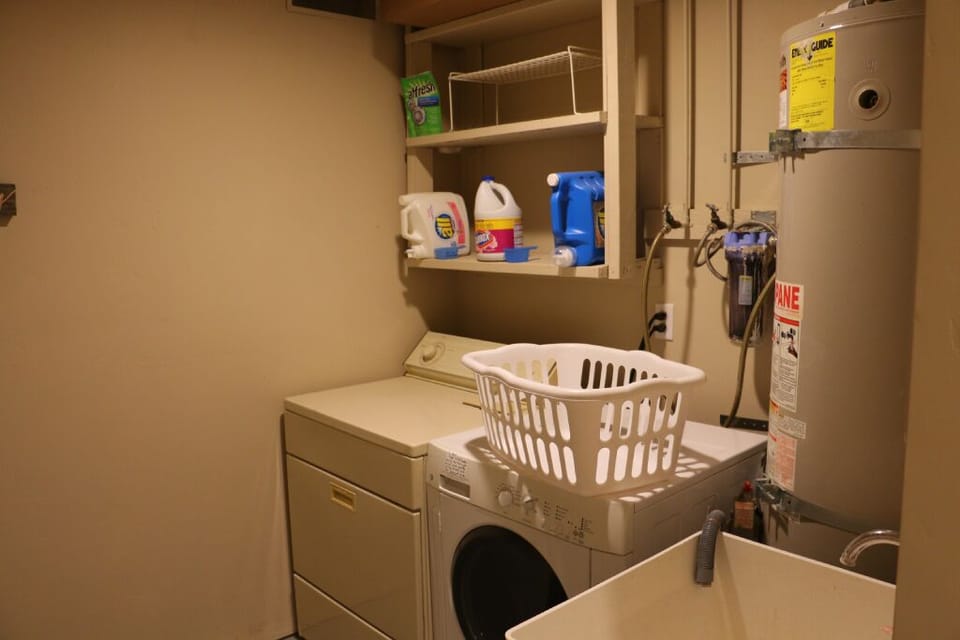 Washer and dryer station with sink, detergent and bleach.