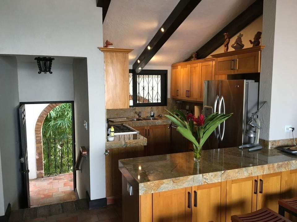 Kitchen has stone countertops and a 6-burner gas range.