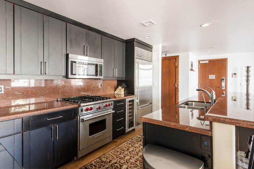 Fully equipped kitchen featuring bottom freezer stainless steel fridge, dedicated wine fridge, wolf gas range
