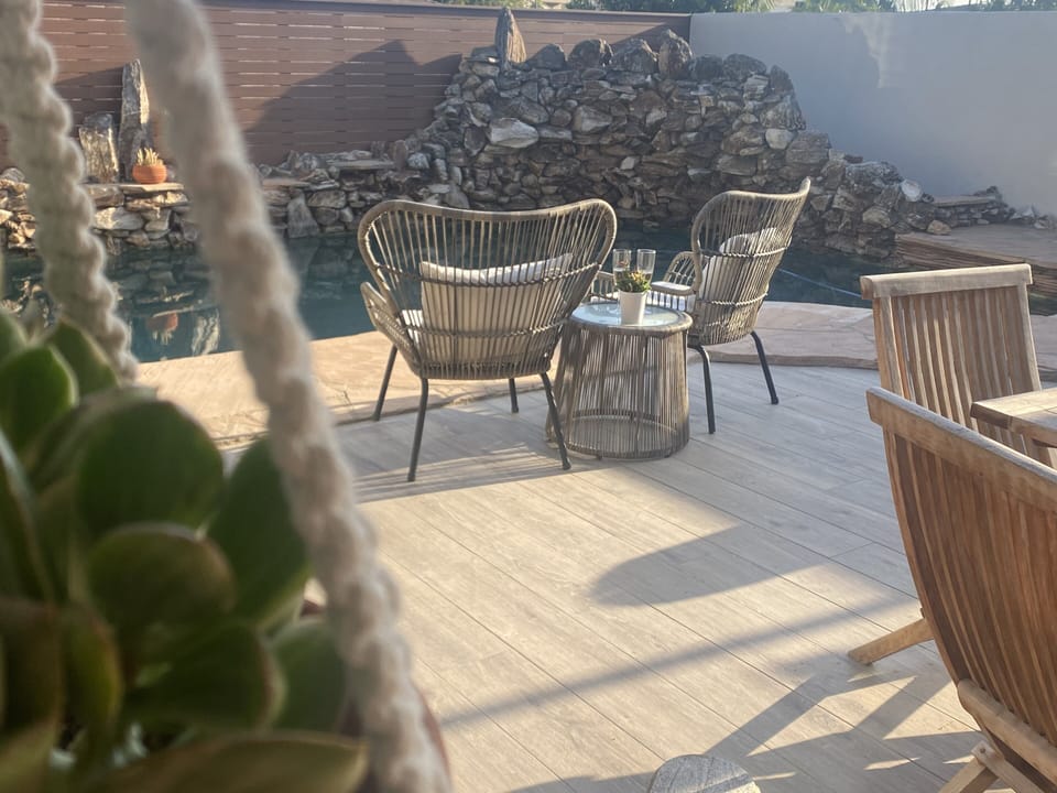 Outdoor patio with private pool, chairs, dining table, grill, and fireplace