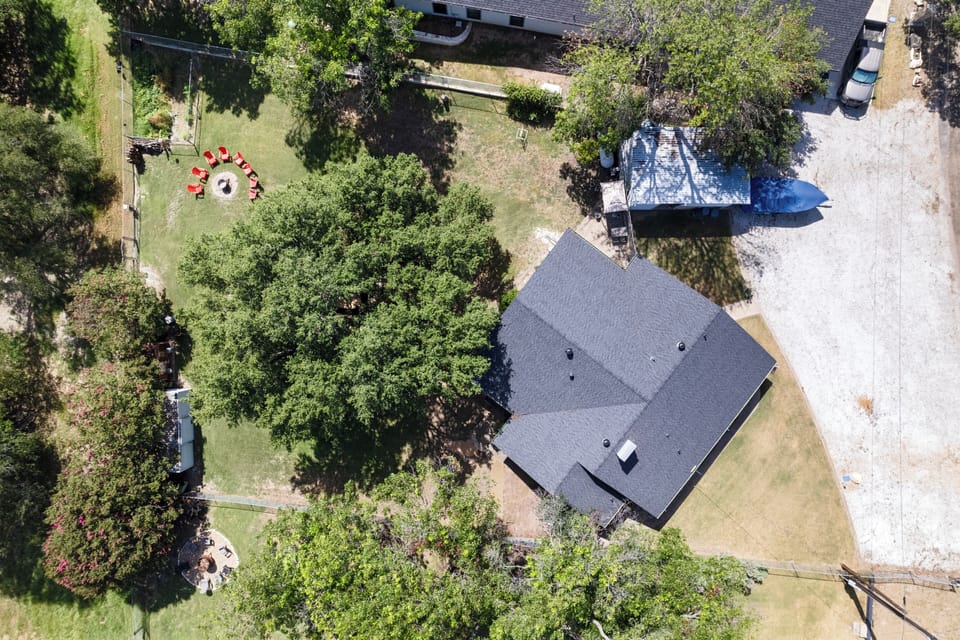 Aerial view of full property, fenced backyard, parking