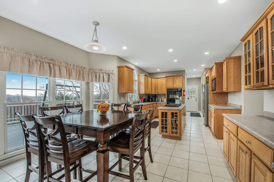 Full kitchen with table for eight. Two ovens and gas range top.