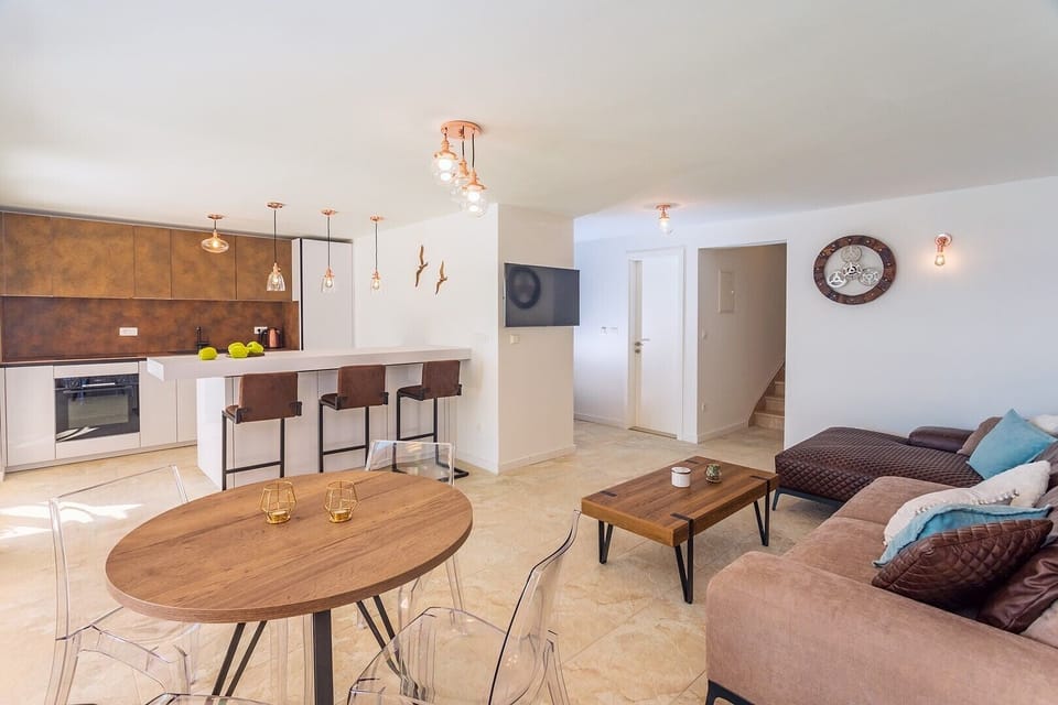 , a living room with TV, A/C, sofa, dining area for 4, 