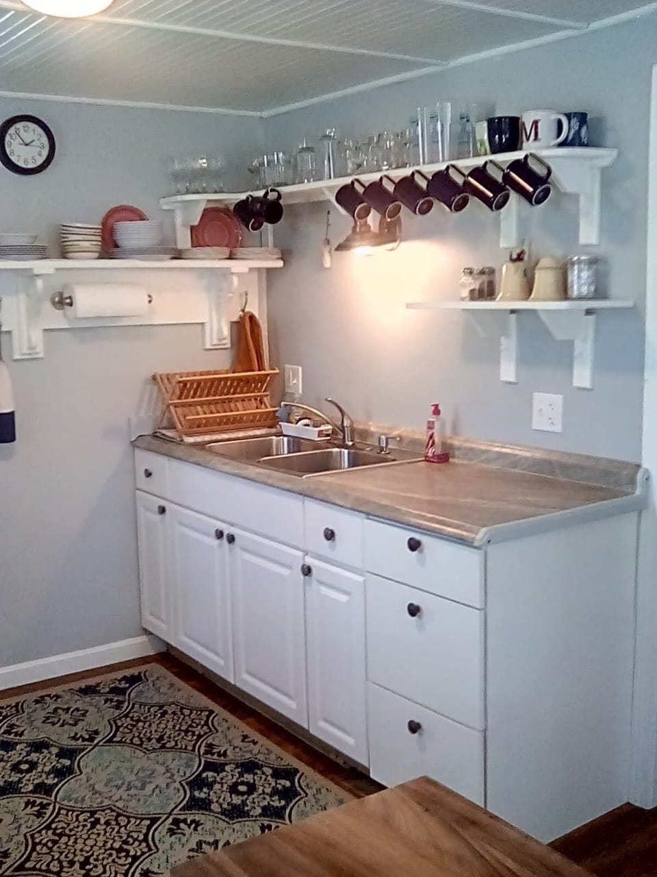 Kitchen has open shelves to find glasses and dishes easily.