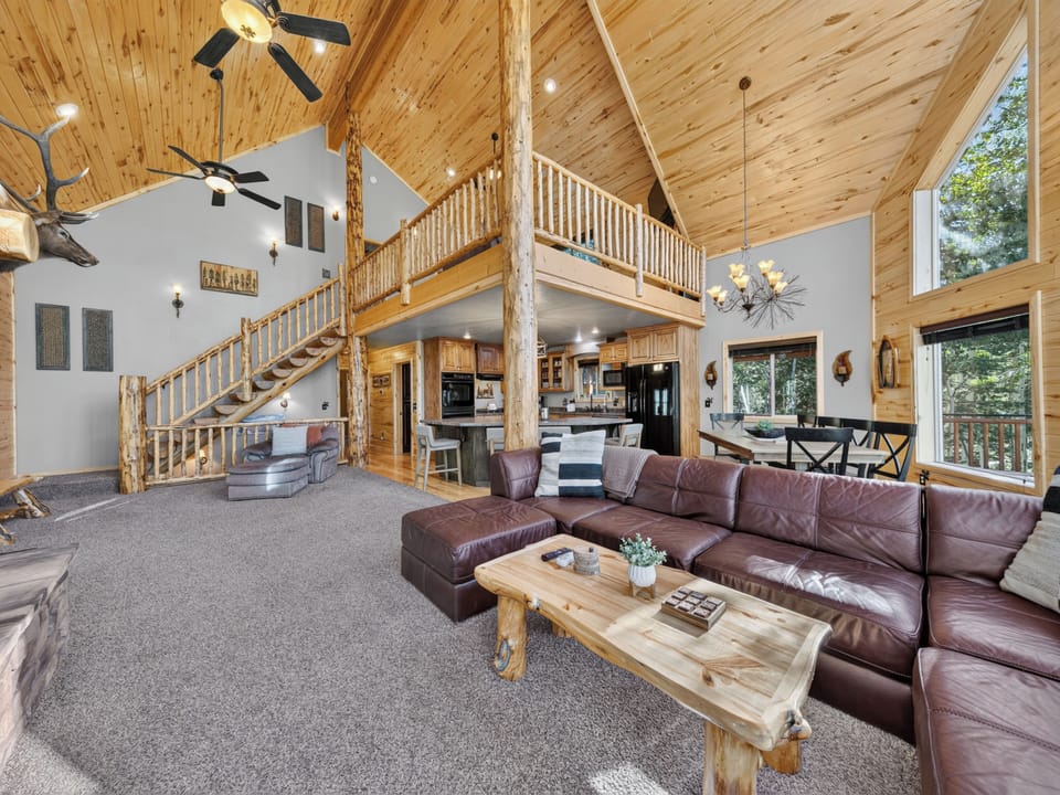 Gather in this stunning great room where soaring vaulted ceilings, rustic wood beams, and a cozy loft create the perfect mountain retreat for your group.