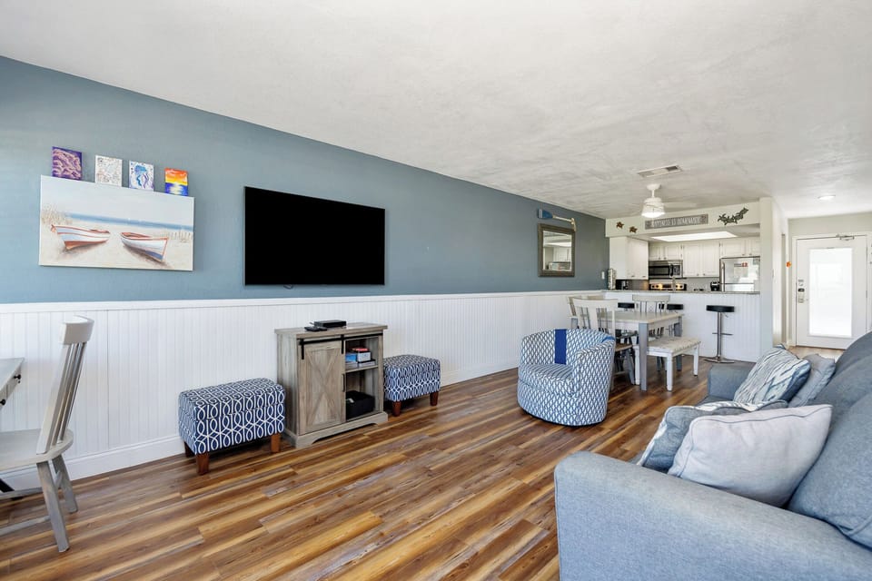 Relax in your spacious living area with comfortable seating, large TV, and open kitchen—perfect for unwinding after beach days.
