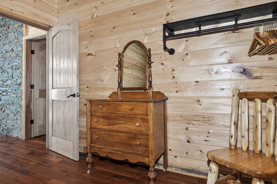 Step into your cozy log cabin bedroom featuring vintage charm with authentic wood walls and antique furnishings.