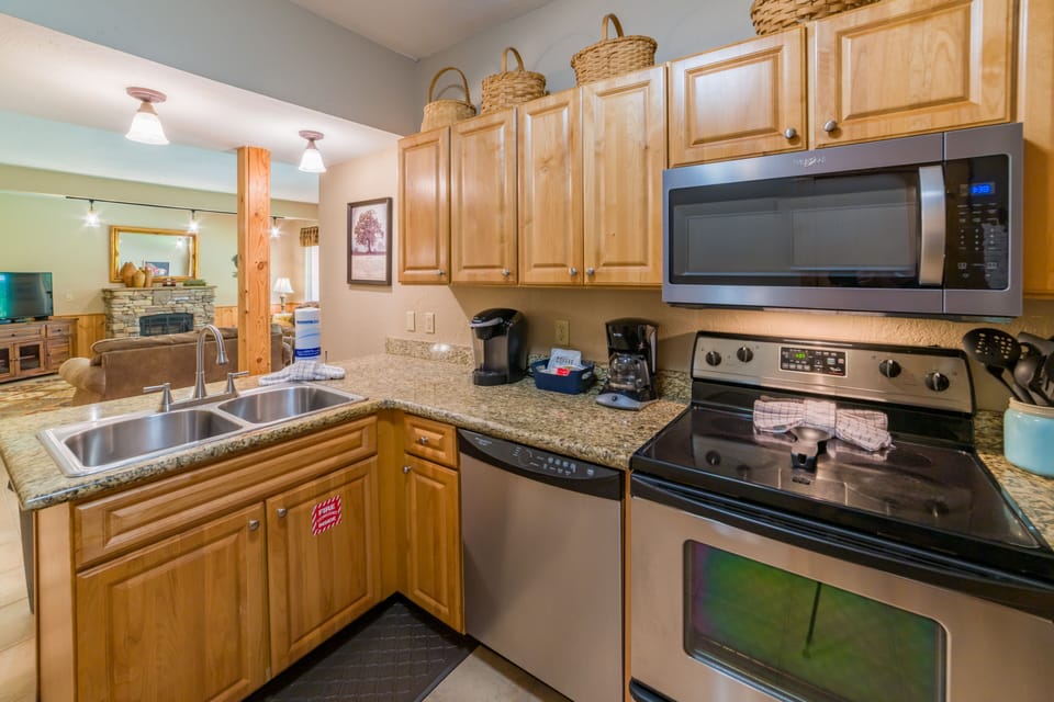 Fully stocked kitchen features stove, oven, microwave, fridge, and coffee makers
