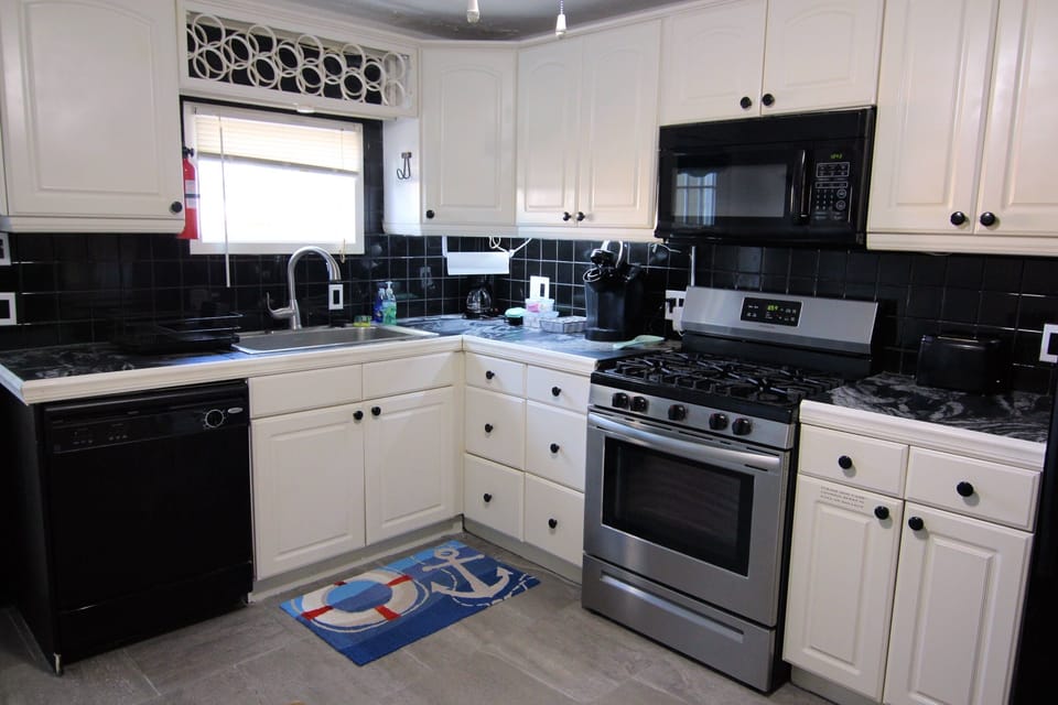 Bright kitchen with gas stove, microwave, and full cookware
