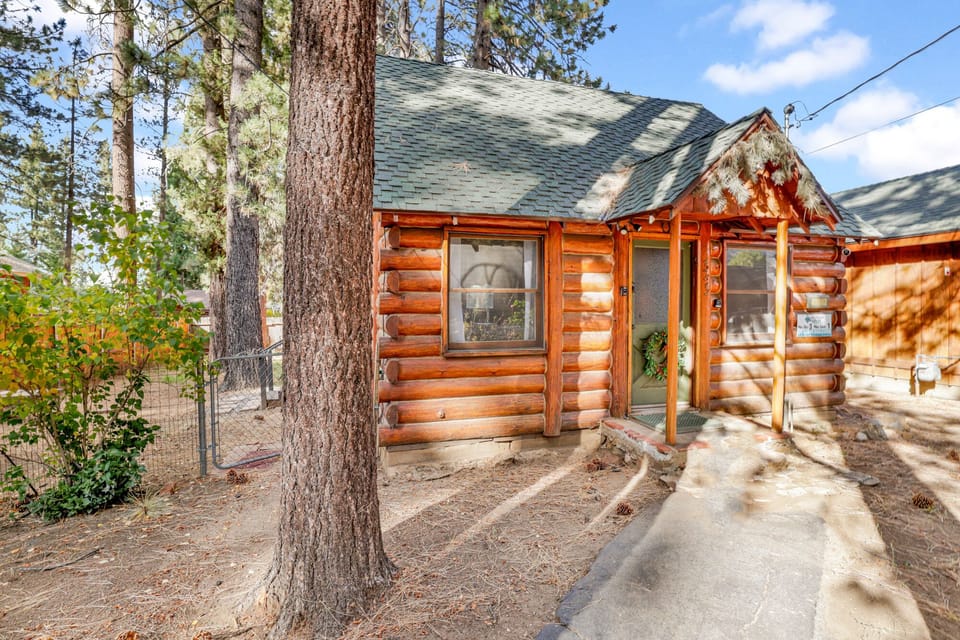 Welcoming cabin entry surrounded by towering pine trees, offering fresh mountain air and a peaceful forest setting—the perfect first impression for your Big Bear Lake getaway.
