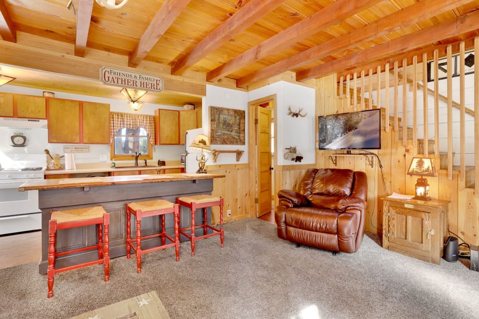 Fully equipped cabin kitchen with cabinets, stove, fridge, coffee maker, and dining table—perfect for home-cooked meals, morning coffee, and a cozy, comfortable stay.